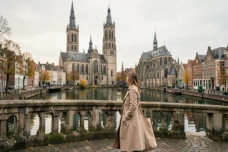 Femme sur le pont Sint-Michielsbrug à Gand avec vue sur les trois tours emblématiques et les quais du Graslei