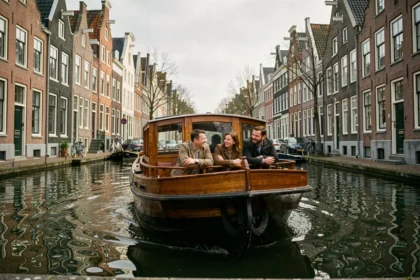 Bateau de croisière sur les canaux d'Amsterdam longeant des maisons à pignons du XVIIe siècle
